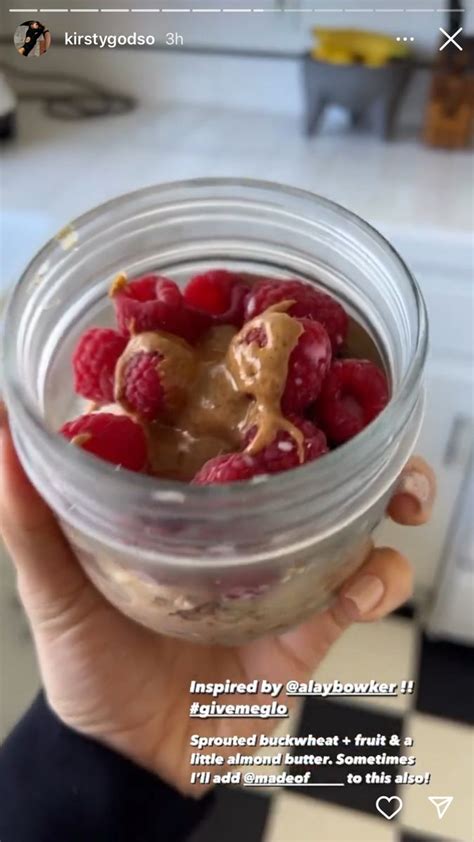 A Person Holding A Jar Filled With Raspberries And Peanut Butter On Top