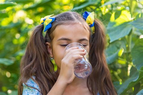 El Ni O Bebe Agua De Un Vaso Enfoque Selectivo Foto Premium