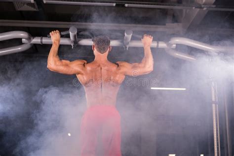 Athlete Muscular Fitness Male Model Pulling Up On Horizontal Bar In A