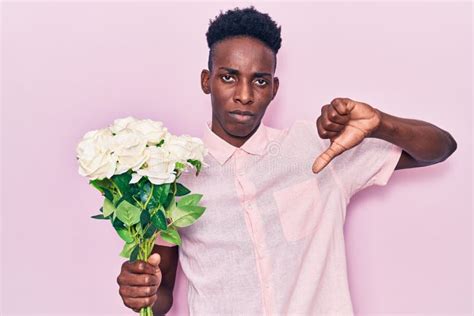 Young African American Man Holding Flowers With Angry Face Negative