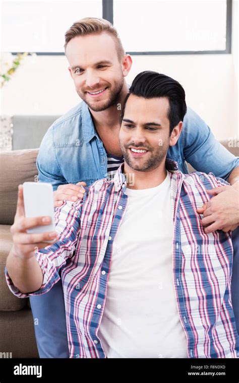 Gay Couple Relaxing On The Couch Taking Selfie Stock Photo Alamy