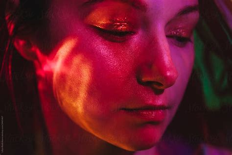 Closeup Beauty Portrait Of Attractive Woman In Purple Light Looking