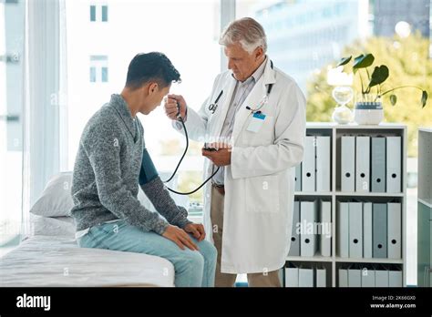 Un homme de race blanche mature médecin effectuant un examen de contrôle de la tension