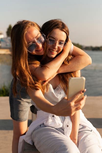 Vue De Face De Deux Femmes Prenant Un Selfie Au Bord Du Lac Photo