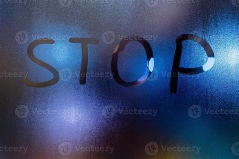 The Word Stop Written On Night Wet Window Glass Close Up With Blurred