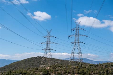 Líneas eléctricas de alta tensión y pilones sobre fondo de cielo azul