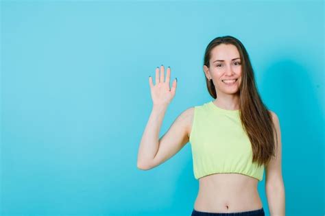 La Chica Sonriente Muestra Un Gesto De Saludo Levantando La Mano Sobre