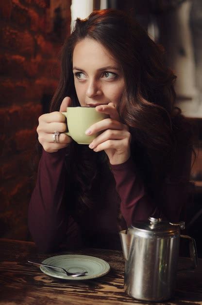 Belle Fille Assise Dans Le Café Boit Du Café Et Regarde Par La Fenêtre