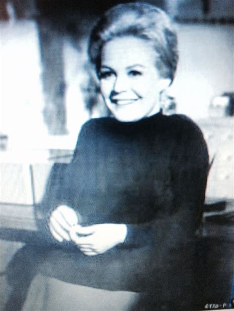 An Old Black And White Photo Of A Woman In A Sweater Smiling At The Camera