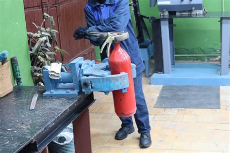 A Man Working On Industrial Vice With A Huge Gas Wrench Unscrews A Nut