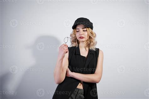 Studio Portrait Of Blonde Girl In Black Wear And Cap Against White Background 10438612 Stock