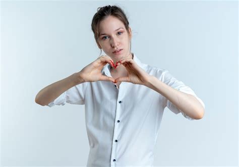 Jeune fille russe blonde confiante gestes coeur signe de la main isolé sur un espace blanc avec