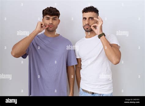 Homosexual Gay Couple Standing Over White Background Mouth And Lips Shut As Zip With Fingers