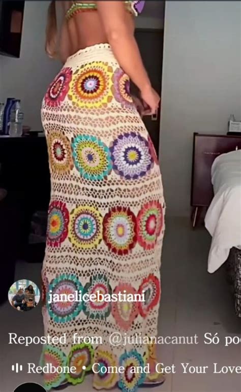 A Woman In A Crocheted Skirt Is Standing Near A Bed