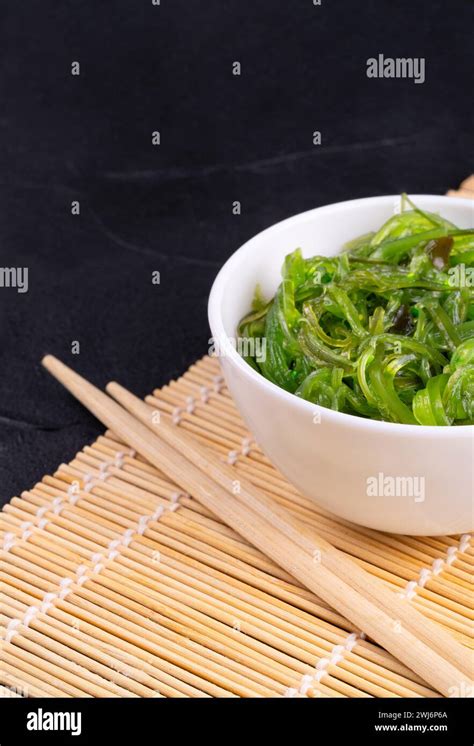 Chuka Seaweed Salad In A White Plate With Chinese Chopsticks On A Mat