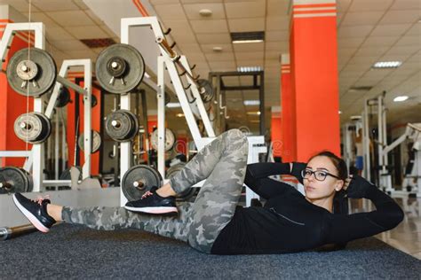 Beautiful Slim Brunette Doing Some Stretching Exercises In A Gym Stock