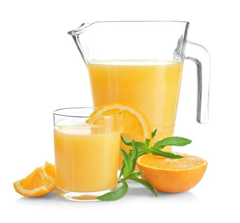 Composición con jarra y vaso de jugo de naranja fresco sobre fondo