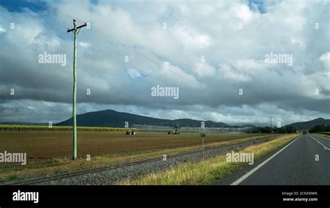 A farmer irrigating his field of sugar cane growing by the side of the ...