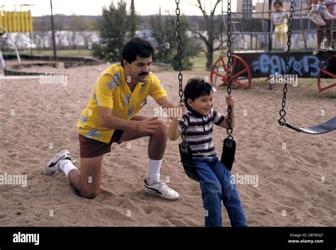 Austin Texas Usa Father Pushes Son On Swing At Neighborhood Park Mr