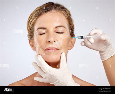 Botox Surgery And Face With Mature Woman Getting An Injection In Her Cheek For Beauty Skincare