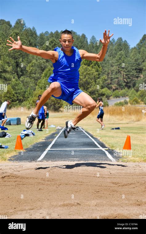 Teenage High School Boy Atleta Soaring Nel Salto In Lungo Pista Di