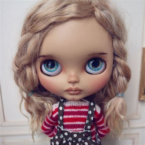 A Doll With Blonde Hair And Blue Eyes Wearing A Red Striped Shirt Black Suspenders And Polka