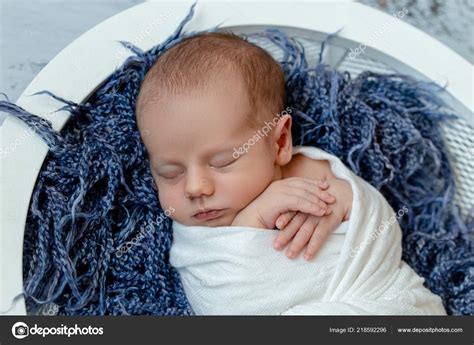 Little Baby Boy Sleeping In A Basket On The Wooden Floor Studio Shot