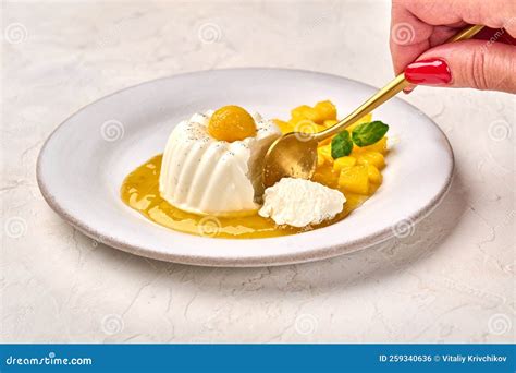 Woman S Hand With Spoon Breaks Off Piece Of Homemade Panna Cotta With