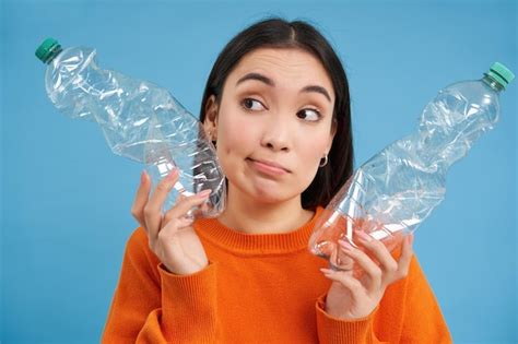 Ragazza Con Due Bottiglie Di Plastica Che Pensano E Guardano Da Parte