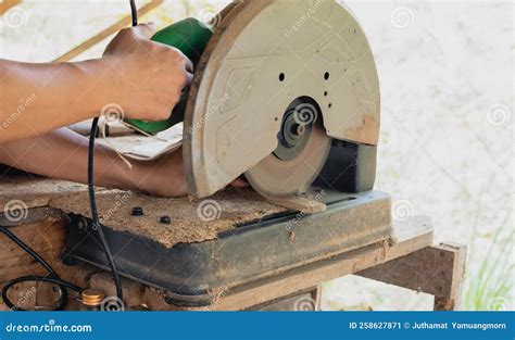 Asian Carpenter Is Using A Circular Saw To Cut Wood To Construct A