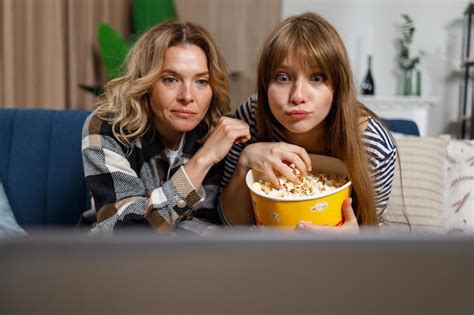 Premium Photo Mature Mother And Adult Daughter Watching Movie On