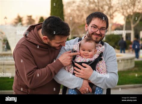 Adorable Gay Couple With Their Month Old Baby In A Baby Carrier Stock Photo Alamy