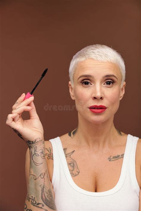 Salope Virile Blonde Avec Des Tatouages Sur Le Bras Et La Poitrine Et Le Rouge à Lèvres Rouge