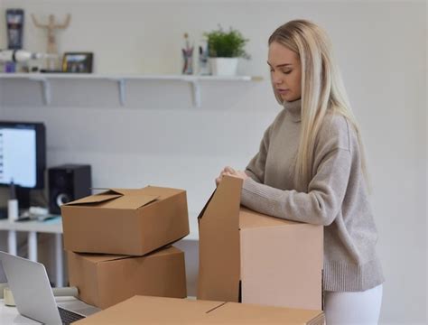 Kaukasisches Mädchen klebt Kisten für den Umzug in eine neue Wohnung