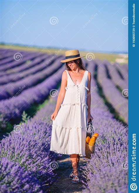 Mujer En El Campo De Flores De Lavanda Al Atardecer Con Vestido Blanco