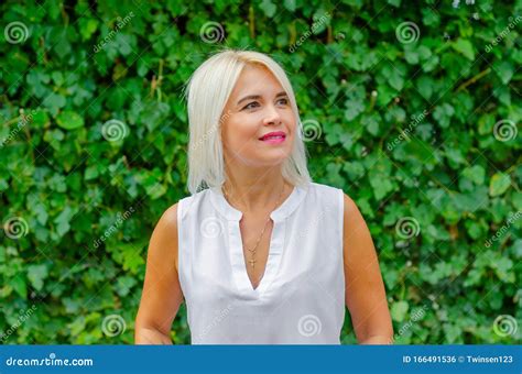 Sch Ne Blonde Frau Mittleren Alters Im Hintergrund Der Gr Nen Bl Tter In Wei Er Bluse Auf Der