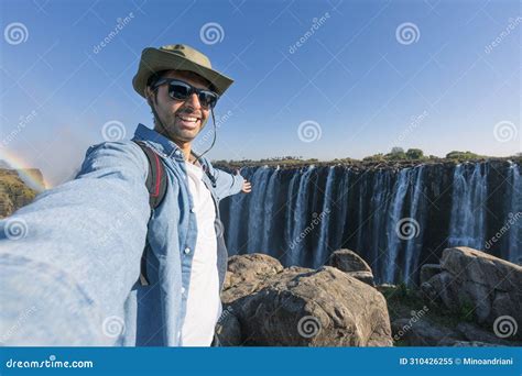 A Tourist Takes A Selfie At Victoria Falls On The Zambezi River