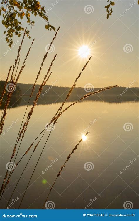 A Beautiful Sunset With Two Suns Reflected In The Lake Stock Photo