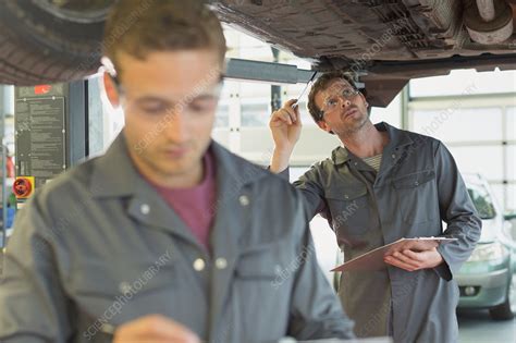 Mechanic With Clipboard Working Under Car Stock Image F