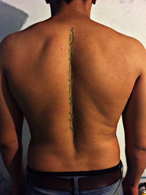 The Back Of A Man With A Tattoo On His Left Shoulder And Right Arm