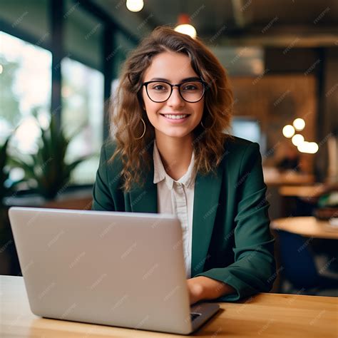 Young happy professional business woman employee sitting at desk