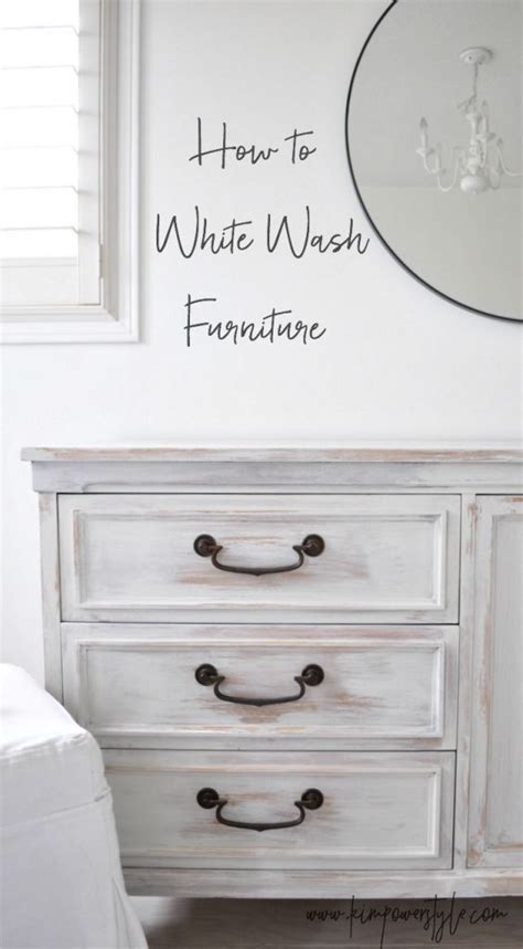 a white dresser sitting next to a window with a mirror above it and the ...