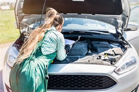 Premium Photo Woman Mechanic Examining Car Engine With Clipboard