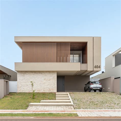 Fachada de casa contemporânea painel brise de madeira e tijolos