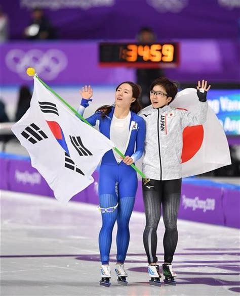 スピードスケート女子500m 銀メダルのライバル、韓国の李相花（イ・サンファ、左）とともに場内の声援に応える小平奈緒＝18日、韓国・江陵