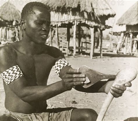 A Tonga Man Sharpens An Axe A Semi Naked Tonga Batonga Man Wearing