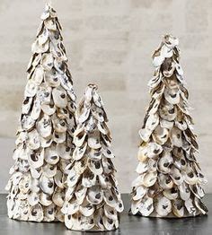 Two Small Trees Made Out Of Seashells On A Table