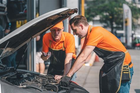 El mecánico de automóviles abre las reparaciones del capó del automóvil