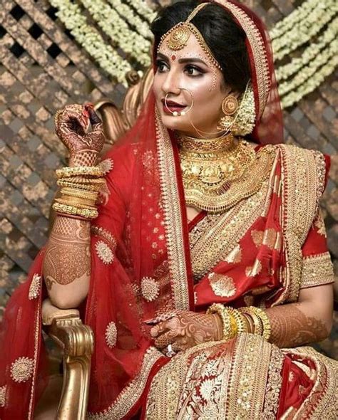 Traditional Red Saree With Intricate Gold Borders And Heavy Jewellery