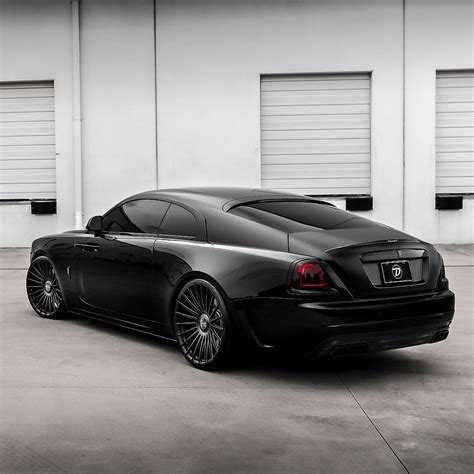 A Black Sports Car Parked In Front Of Two Garage Doors